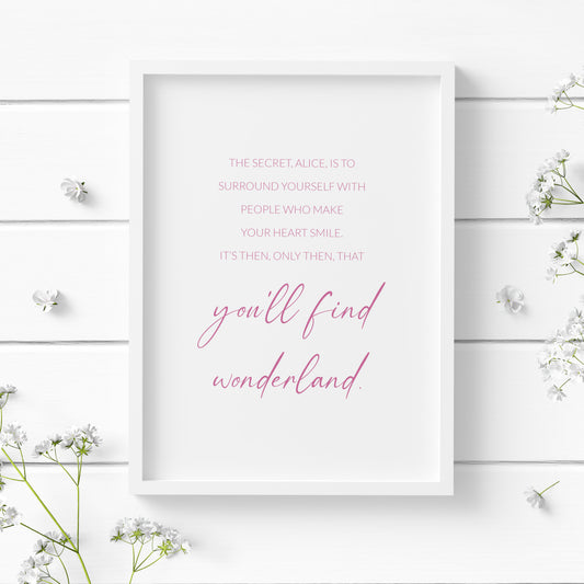 Single portrait typography print featuring a quote from Alice In Wonderland. Text reads: The secret, Alice, is to surround yourself with people who make your heart smile. It's then, only then, that you'll find Wonderland. All text is in a lightweight upper case sans serif font with the exception of the words "you'll find wonderland", which are positioned prominently in a lower case script font. Text is pink on a white background and centre-aligned. Styling is elegant and minimalist.