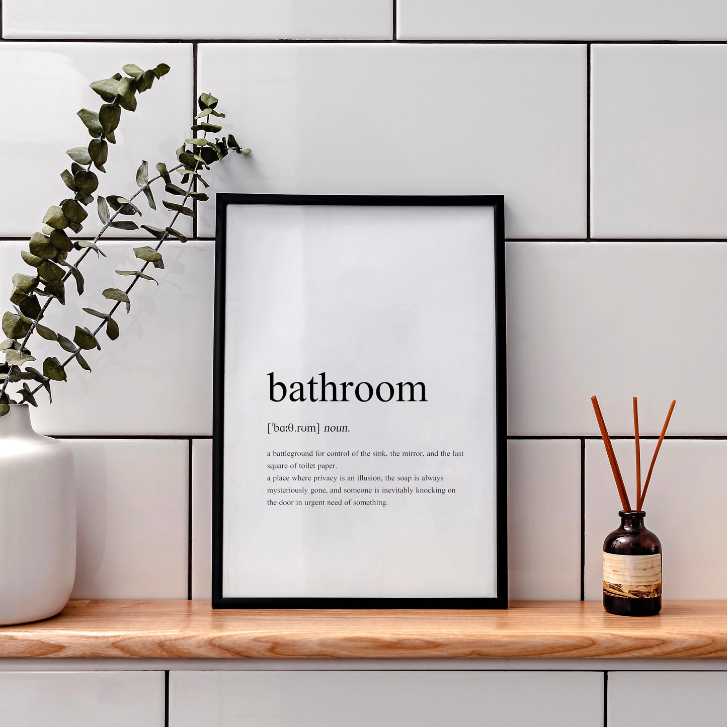 Single portrait typography print featuring a dictionary-style definition of the word bathroom. The word itself, together with its phonetic pronunciation, type and definition are included. Text is in a lower case serif font, black on a white background and left-aligned.
