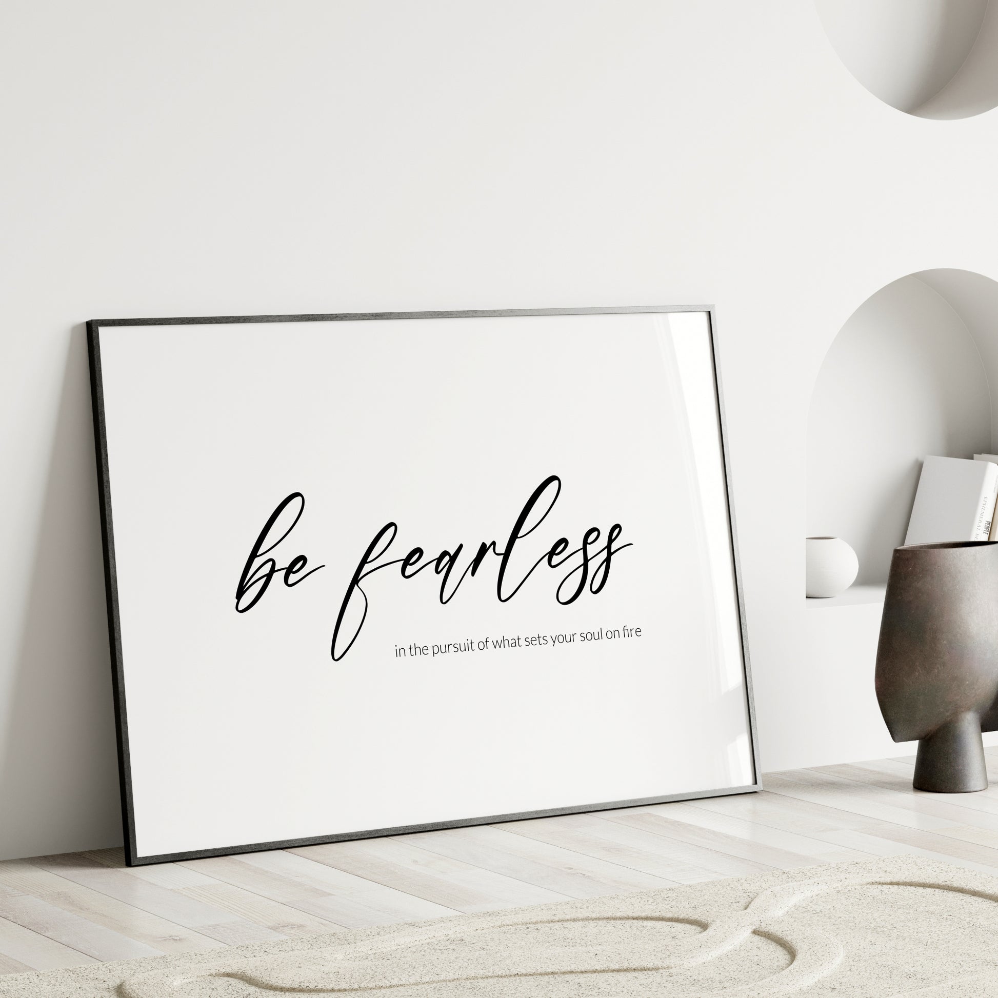 Single landscape typography print. Text reads: Be fearless in the pursuit of what sets your soul on fire. The words "be fearless" are positioned prominently in a modern script font and are centred vertically and horizontally. Remaining text in a lightweight sans serif font aligned to the bottom right of the "be fearless" text. All text is lower case, black on a white background. Styling is contemporary and elegant.
