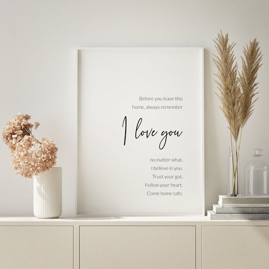 Single portrait typography print. Text reads: Before you leave this home, always remember I love you no matter what. I believe in you. Trust your gut. Follow your heart. Come home safe. The words I Love You are positioned prominently in a modern script font. Remaining text is in a lightweight sans serif font. All text is black on a white background and right-aligned. Styling is contemporary and elegant.
