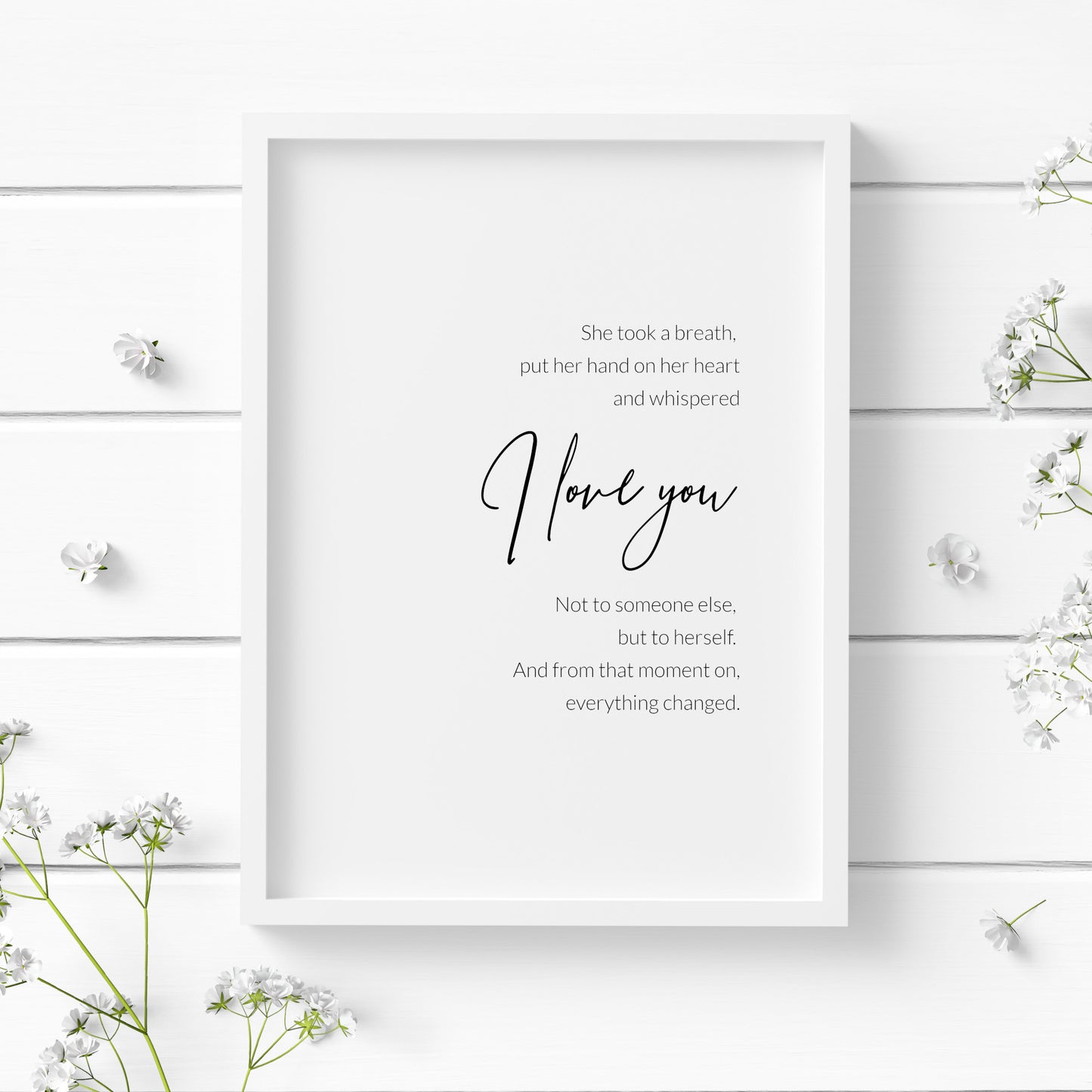Single portrait typography print featuring the quote "She took a breath, put her hand on her heart and whispered I love you. Not to someone else, but to herself. And from that moment on, everything changed.". The words "I love you" are positioned prominently in an elegant script font, with the remaining text in a crisp sans serif font. The full text is right-aligned and centred vertically. Text is black on a white background.