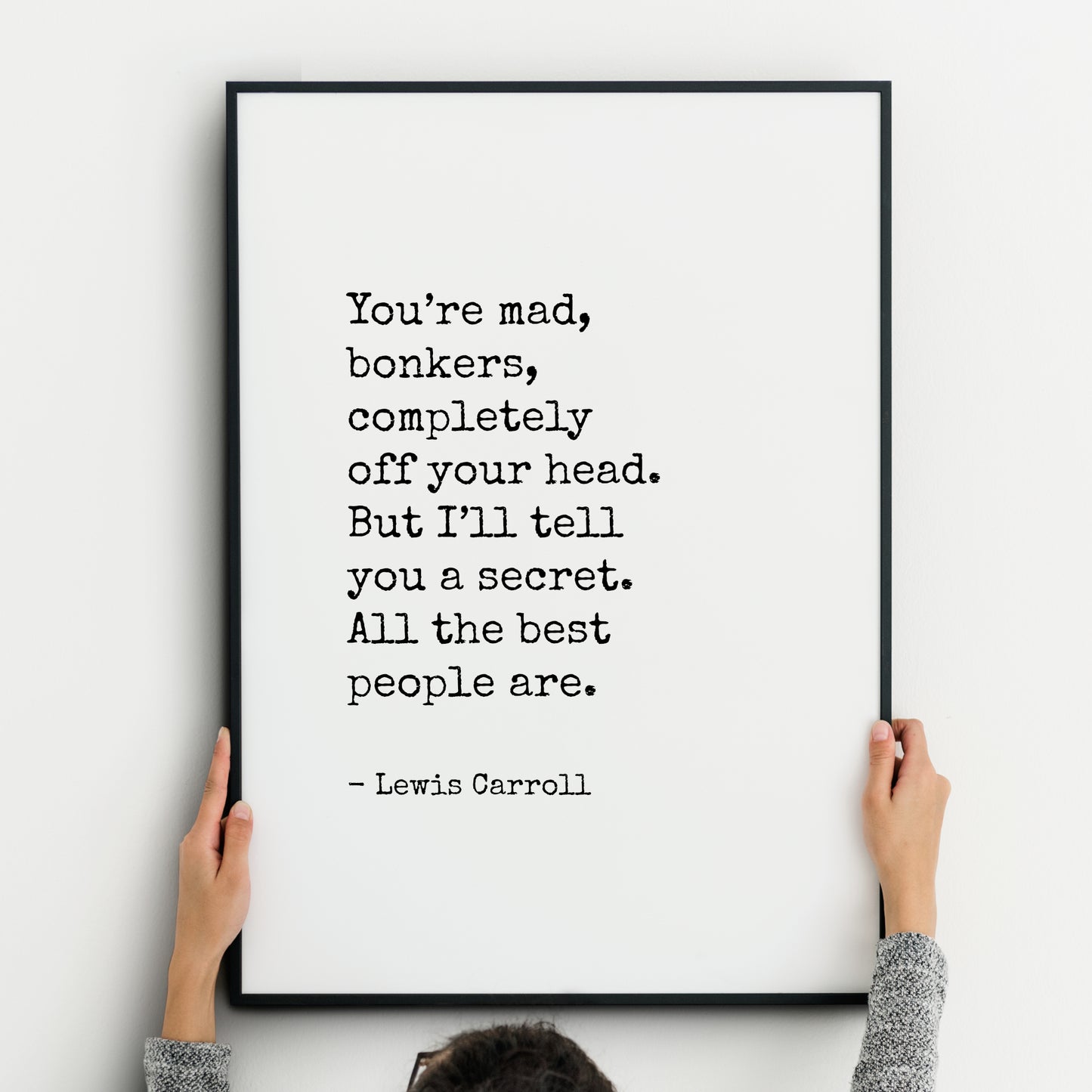 Single portrait typography print. Text reads "You’re mad, bonkers, completely off your head. But I’ll tell you a secret. All the best people are. - Lewis Carroll". Text is in a vintage typewriter style font, black on a white background.