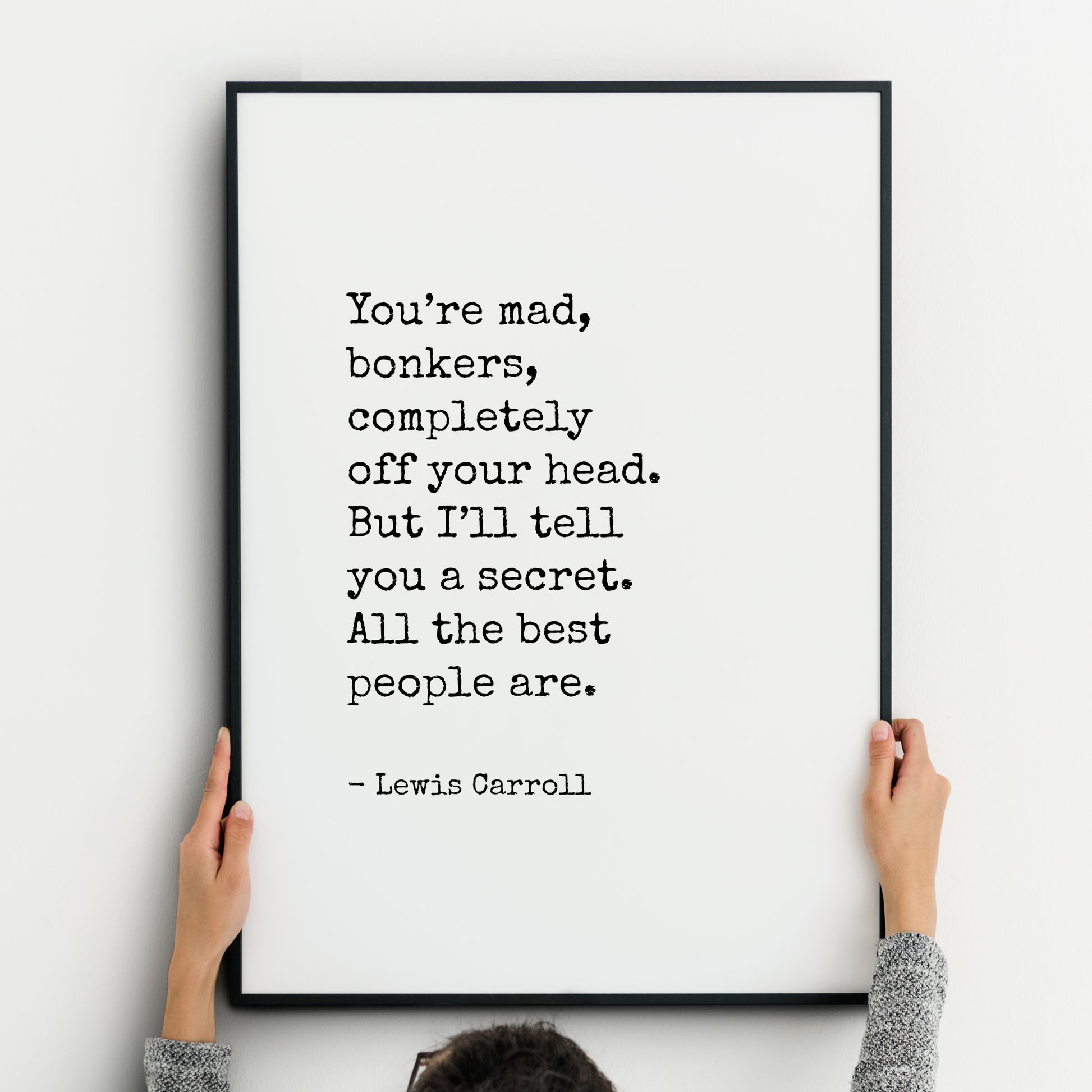 Single portrait typography print. Text reads "You’re mad, bonkers, completely off your head. But I’ll tell you a secret. All the best people are. - Lewis Carroll". Text is in a vintage typewriter style font, black on a white background.