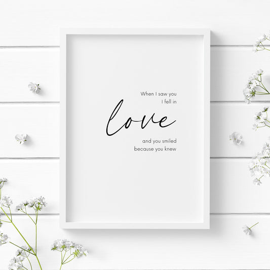 Romantic typography print, with the quote: When I saw you I fell in love and you smiled because you knew.  The word love is displayed prominently in an elegant script font. Orientation is portrait and text is black on a white background.