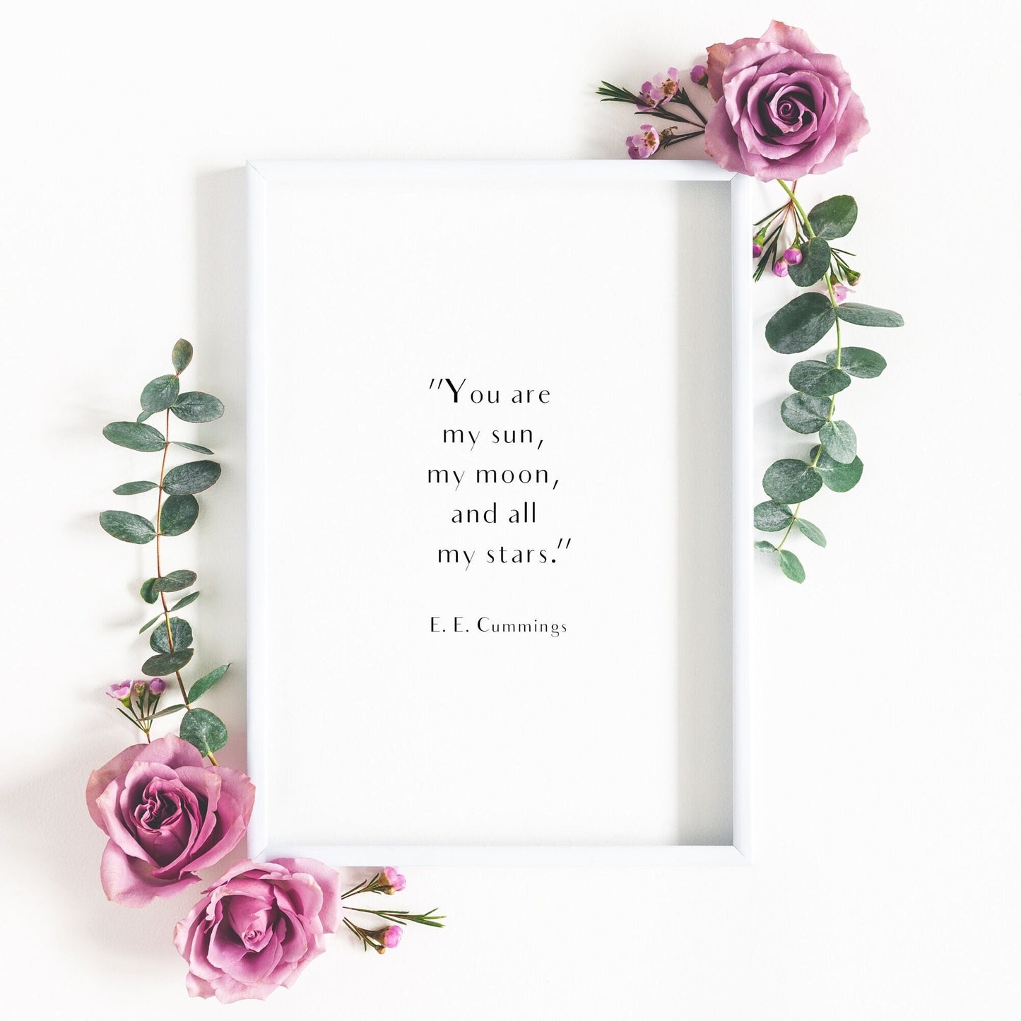 Single portrait typography print shown in a romantic setting. Text reads: "You are my sun, my moon, and all of my stars". This is followed by an attribution to E. E. Cummings.. Text is in an elegant sans serif font, black on a white background.
