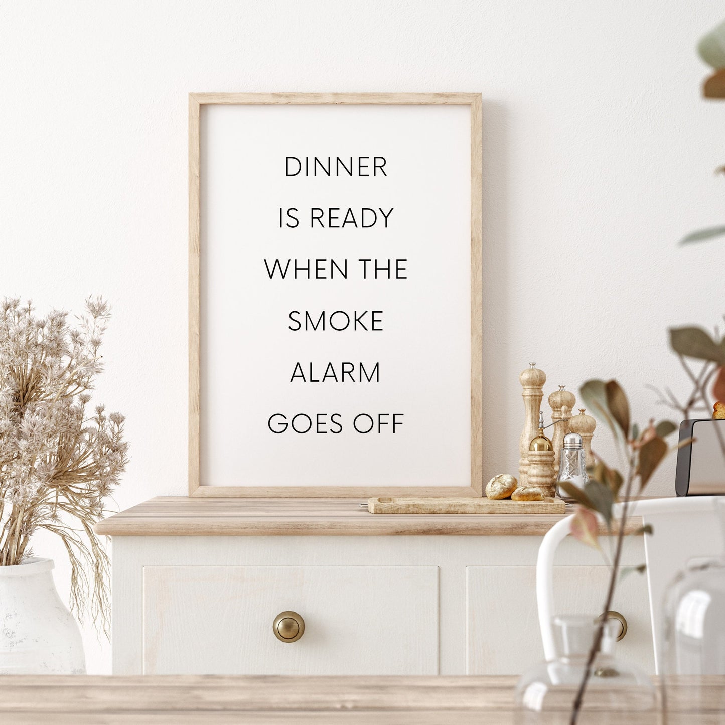 Single portrait typography print featuring the quote: Dinner is ready when the smoke alarm goes off. Text is in a modern upper case sans serif font. Text is black on a white background.