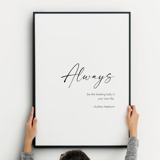 Single portrait typography print. Text reads: Always be the leading lady in your own life. - Audrey Hepburn. The word always is emphasised in a large script font. Remaining text is in a smaller sans serif font. Text is black on a white background.