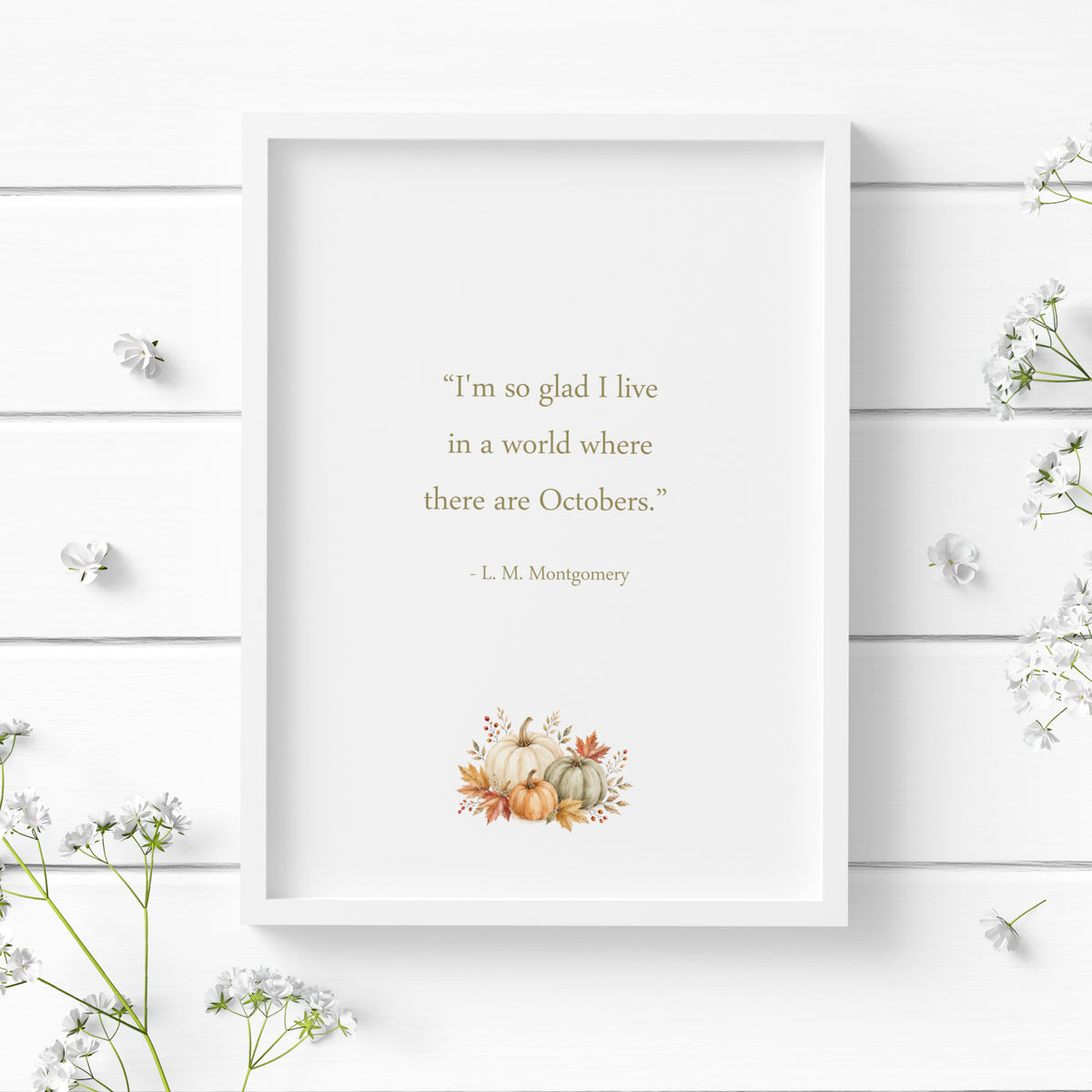 Single portrait illustrated typography print featuring the autumn quote “I’m so glad I live in a world where there are Octobers” by L. M. Montgomery above a delicate watercolour arrangement of pumpkins, autumn leaves and berries.