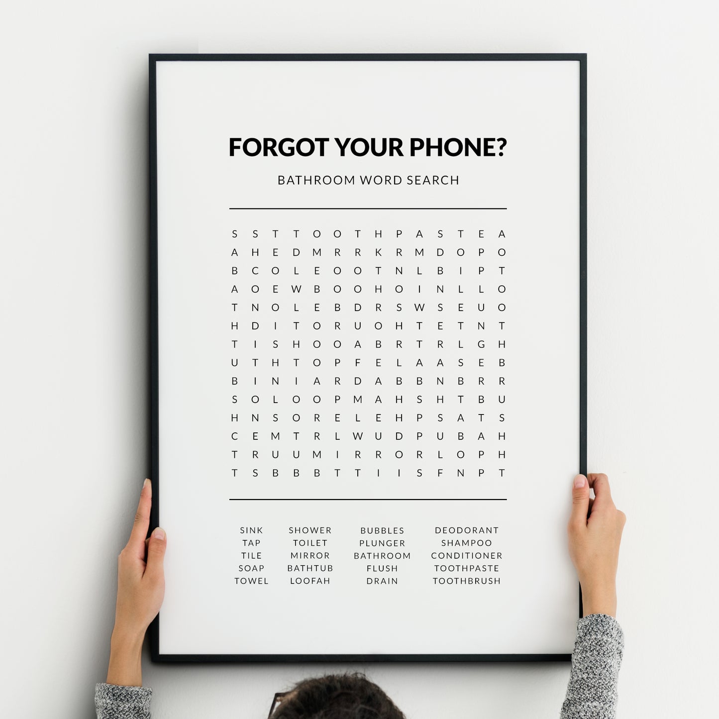 Bathroom word search print featuring the heading “Forgot your phone?” with a grid puzzle and a list of bathroom-related words below, presented in clean black typography on a white background.