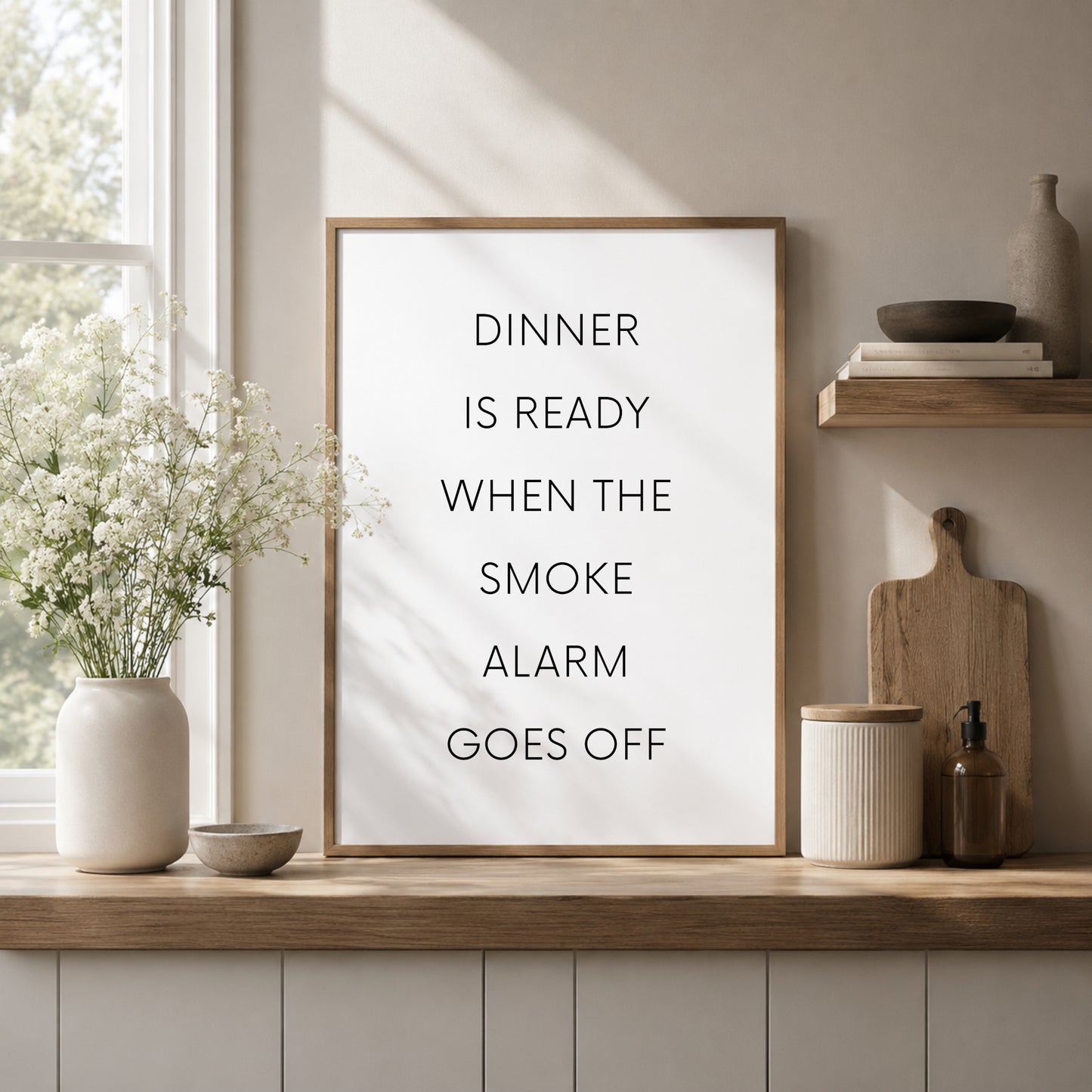 Single portrait typography print featuring the quote: Dinner is ready when the smoke alarm goes off. Text is in a modern upper case sans serif font. Text is black on a white background.