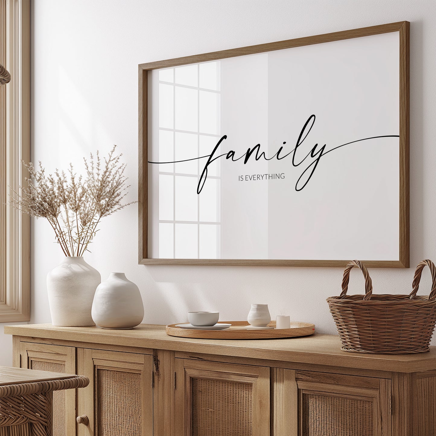 Single landscape typography print. Text reads: family is everything. The word "family" is positioned prominently in an elegant script font, with trailing ends to the lead and end letters, extending to the edges of the print. The remining text is in a crisp upper case sans serif font. Text is centre-aligned and black on a white background.