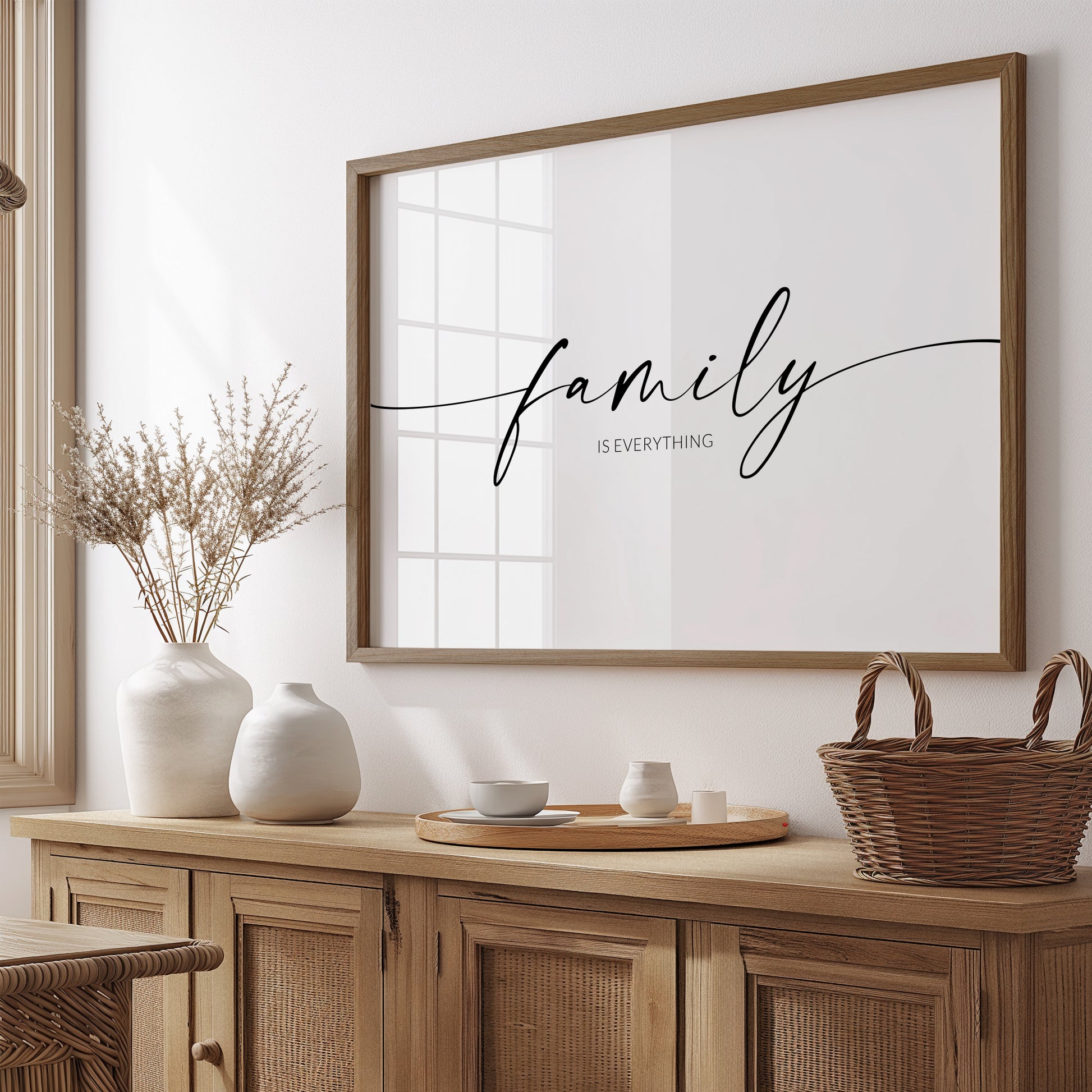 Single landscape typography print. Text reads: family is everything. The word "family" is positioned prominently in an elegant script font, with trailing ends to the lead and end letters, extending to the edges of the print. The remining text is in a crisp upper case sans serif font. Text is centre-aligned and black on a white background.