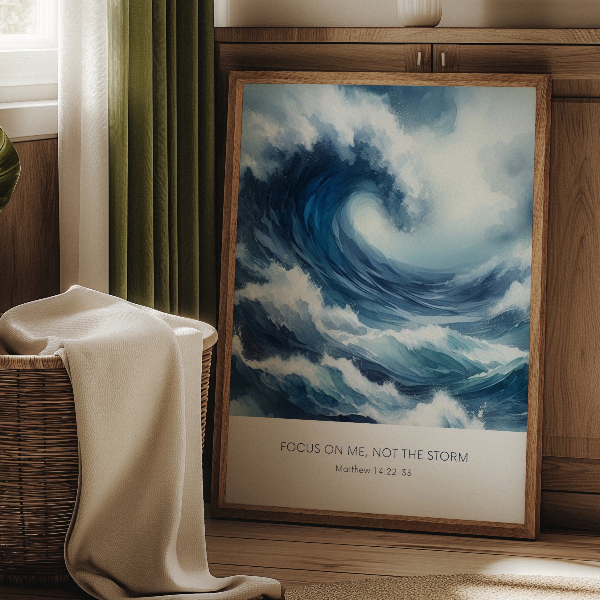Single portrait illustrated print. Illustration is of a stormy sea showing a large crashing way in moody shades of blue and white. A bible verse is positioned below, reading: Focus on me, not the storm. An attribution to Matthew 14:22-33 is positioned below that again. All text is centre-aligned and in a sans serif font. Text is dark blue on a white background. Styling is contemporary and elegant.