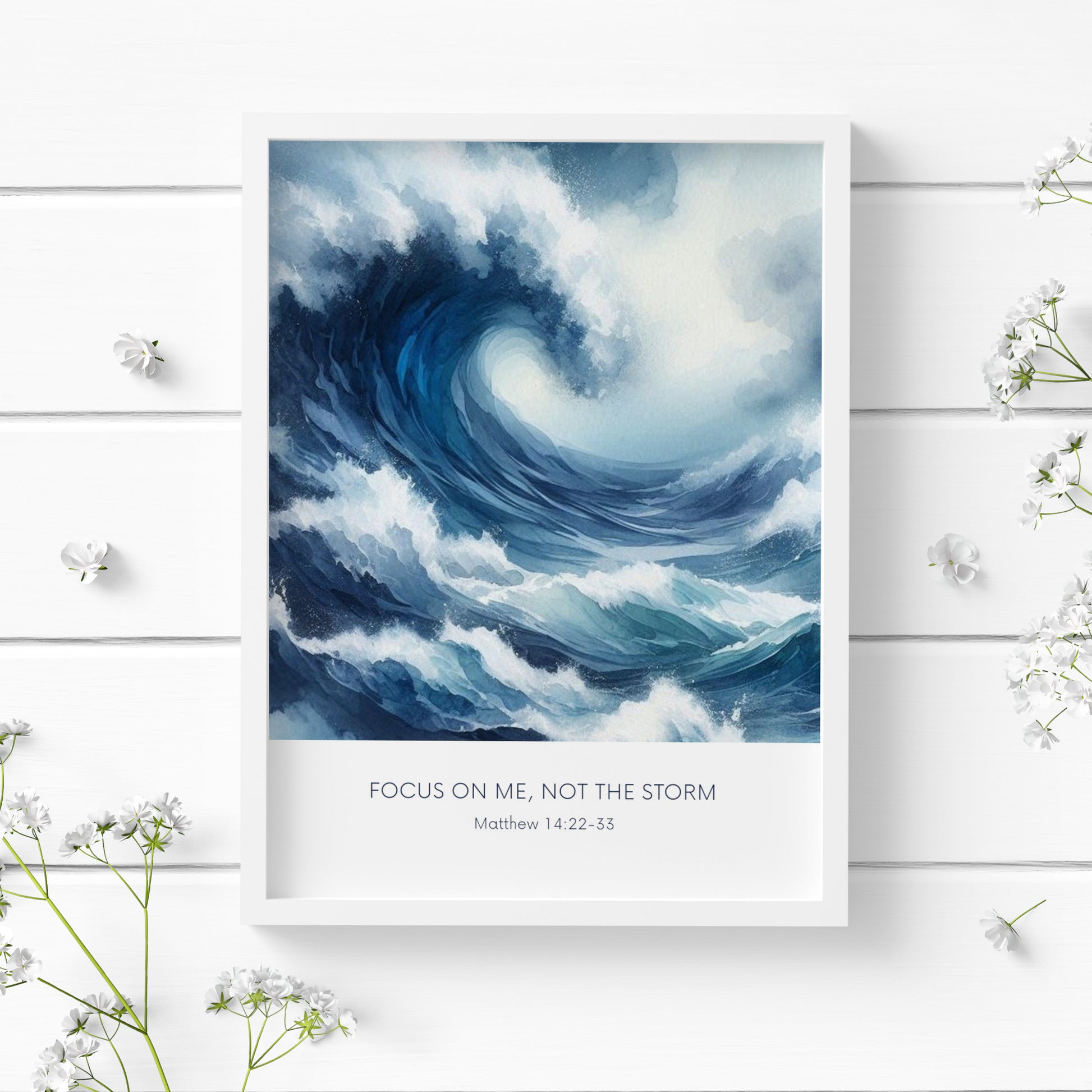 Single portrait illustrated print. Illustration is of a stormy sea showing a large crashing way in moody shades of blue and white. A bible verse is positioned below, reading: Focus on me, not the storm. An attribution to Matthew 14:22-33 is positioned below that again. All text is centre-aligned and in a sans serif font. Text is dark blue on a white background. Styling is contemporary and elegant.