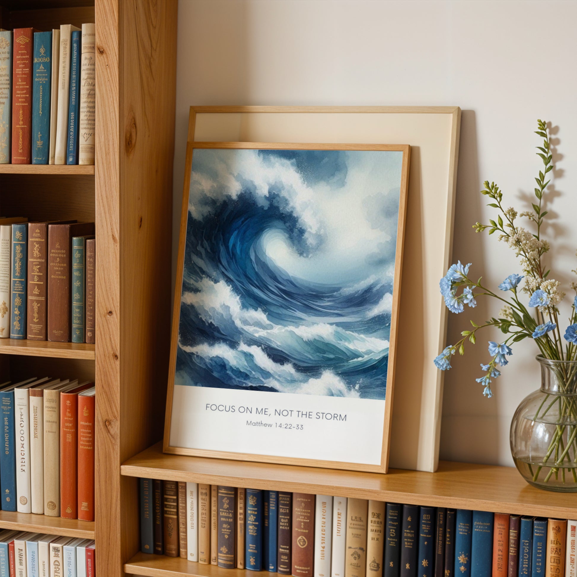 Single portrait illustrated print. Illustration is of a stormy sea showing a large crashing way in moody shades of blue and white. A bible verse is positioned below, reading: Focus on me, not the storm. An attribution to Matthew 14:22-33 is positioned below that again. All text is centre-aligned and in a sans serif font. Text is dark blue on a white background. Styling is contemporary and elegant.
