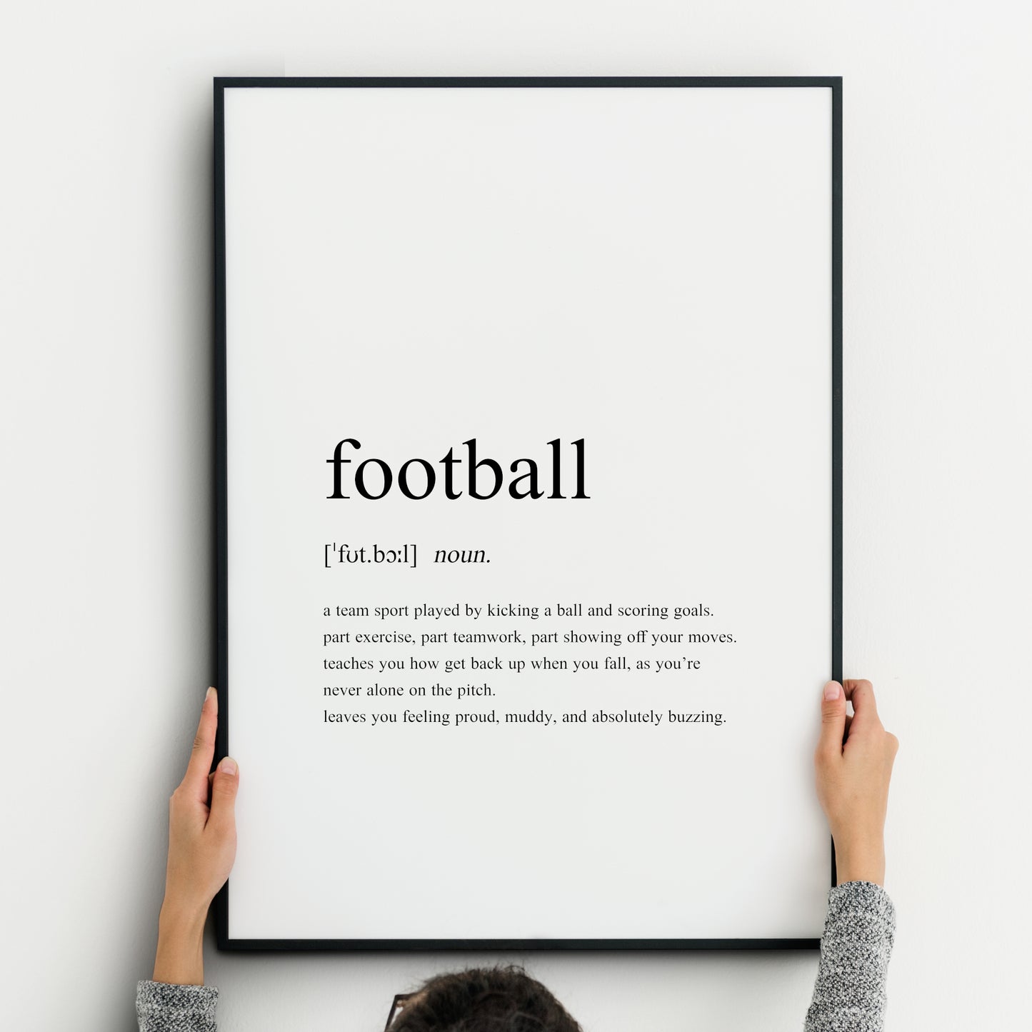 Single portrait typography print featuring a dictionary style definition of the word Football. It includes the word itself, its pronunciation, word type and then the definition. All text is black on a white background and left-aligned.