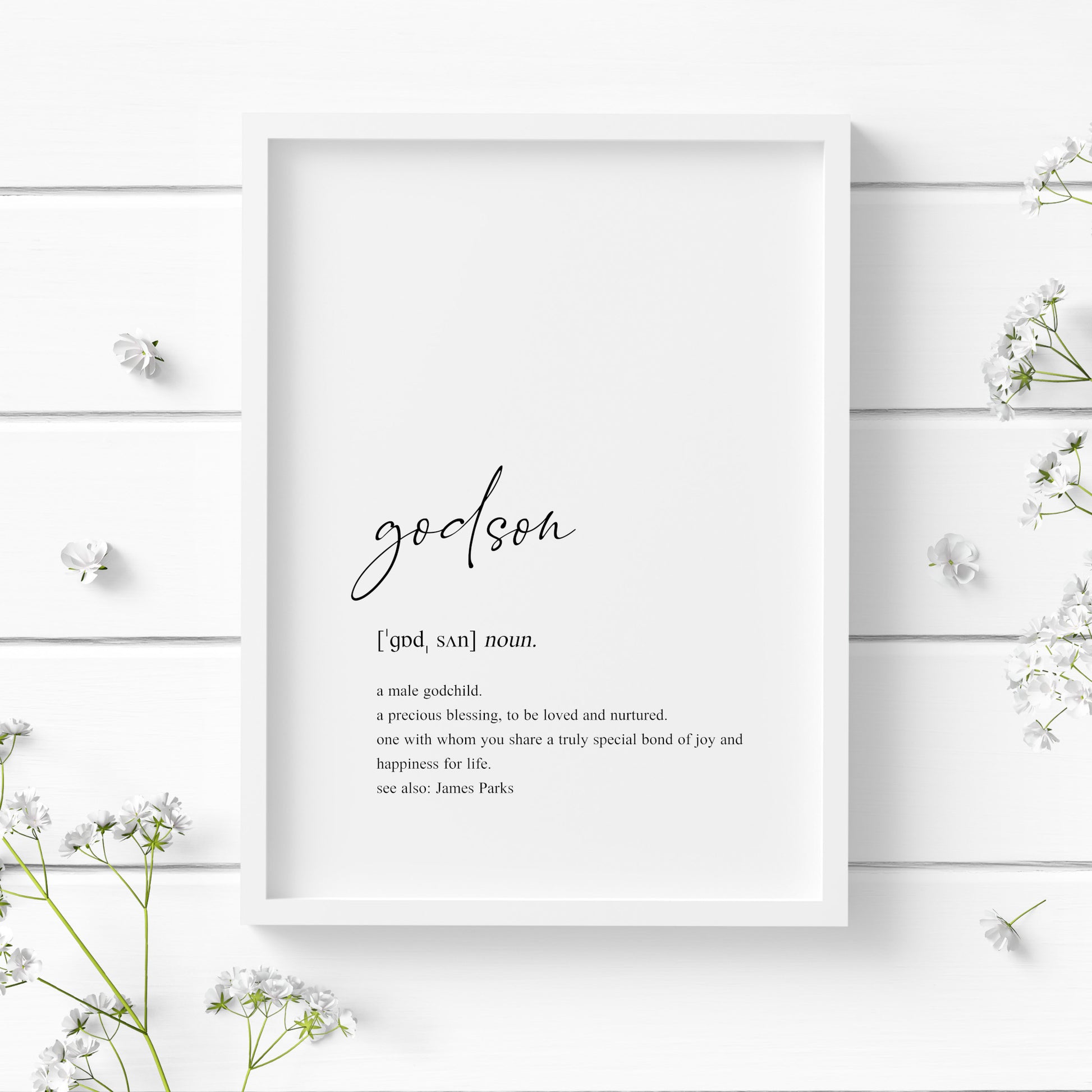 Single portrait typography print showing a dictionary style definition of the word godson. The word godson is in a modern script font, with the remaining text in a lower case serif font. The print is personalised with the name of the godson in a "see also:" section at the end of the definition. Text is black on a white background.