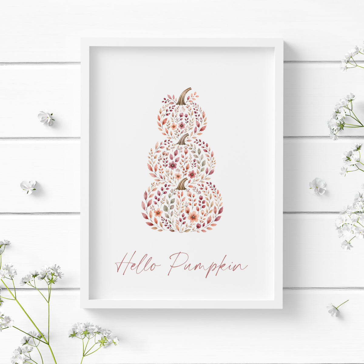 Single portrait illustrated typography print featuring the text "Hello Pumpkin" below a stack of three pumkpins. Text and illustration are in warm autumnal tones with text in a contemporary script font. Styling is cosy cottagecore.