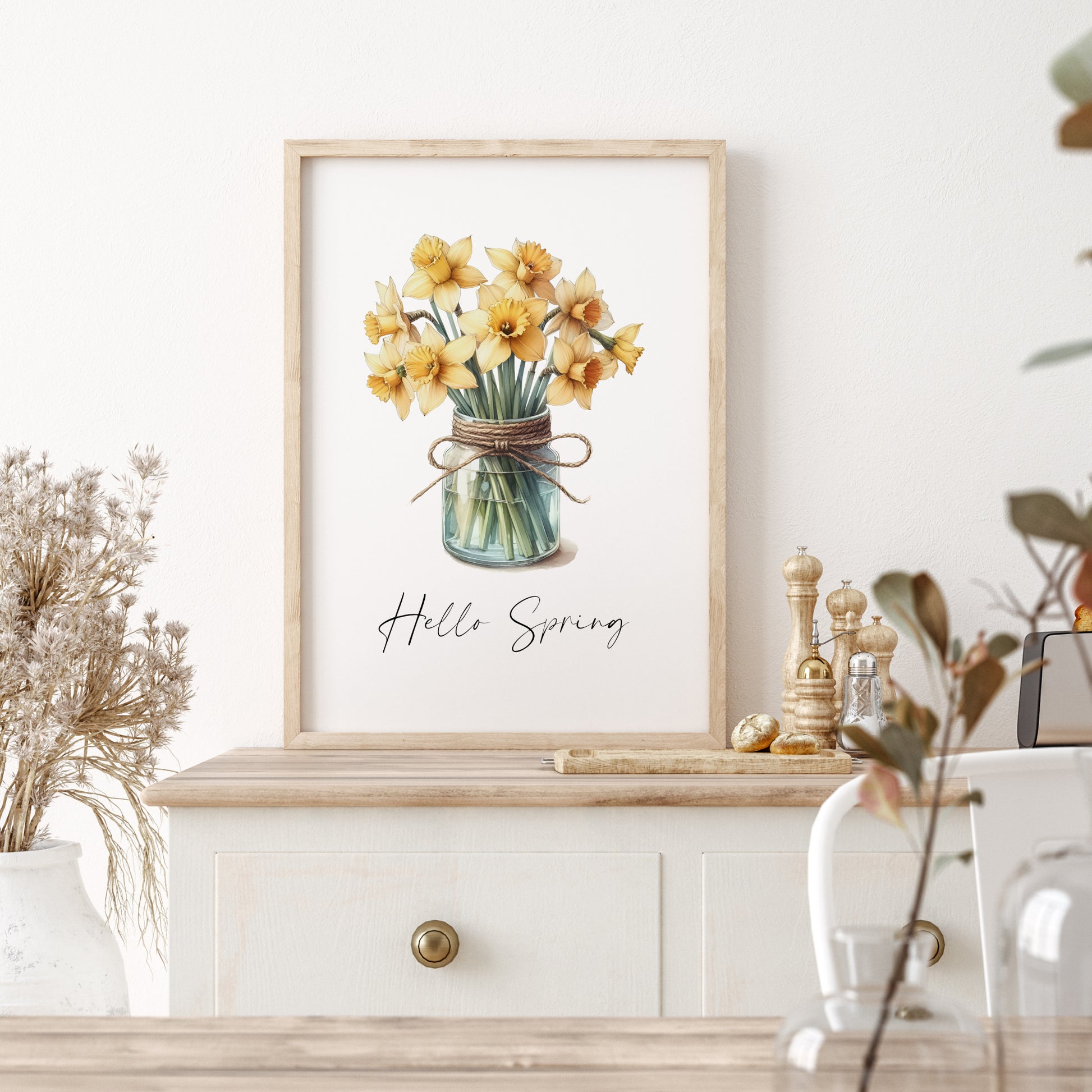 Single portrait print featuring an illustration of yellow spring flowers (daffodils) in a mason jar. The text &quot;Hello Spring&quot; is positioned below the image. Text is black on a white background and in a modern script font.