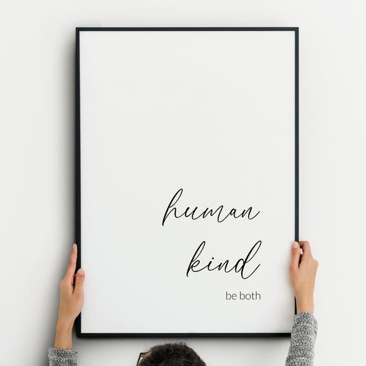 Minimalist typography print featuring the phrase ‘human kind be both’. The words ‘human’ and ‘kind’ are prominent and written in an elegant, flowing script font with soft curves. The remaining text is in a lightweight sans serif font. The text is right and bottom aligned, black on a white background. Styling is simple, modern, and calming.