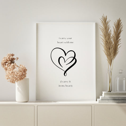 Single portrait print. An line art image of two intertwined hearts is positioned prominently in the centre. Text above reads: I carry you heart with me. Text below reads: (I carry it in my heart). All text is in a stylised lower case sans serif font. The line art and all text is black on a white background. Styling is modern, minimalist and elegant.