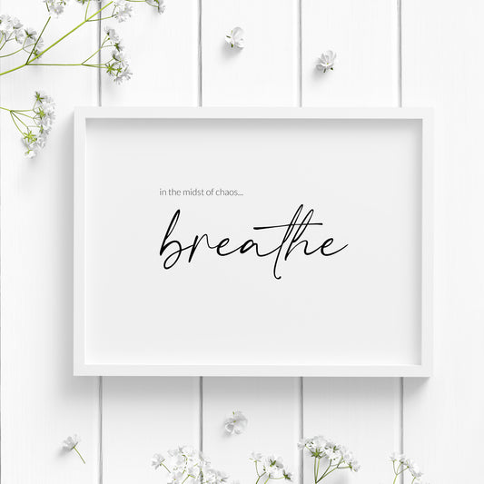Single landscape typography print. Quote reads: In the midst of chaos... breathe. The word "breathe" is positioned prominently in an elegant script font. Remaining text is in a small lightweight sans serif font, positioned to the top left of the word "breathe". Text is white on a black background. Styling is modern and elegant.