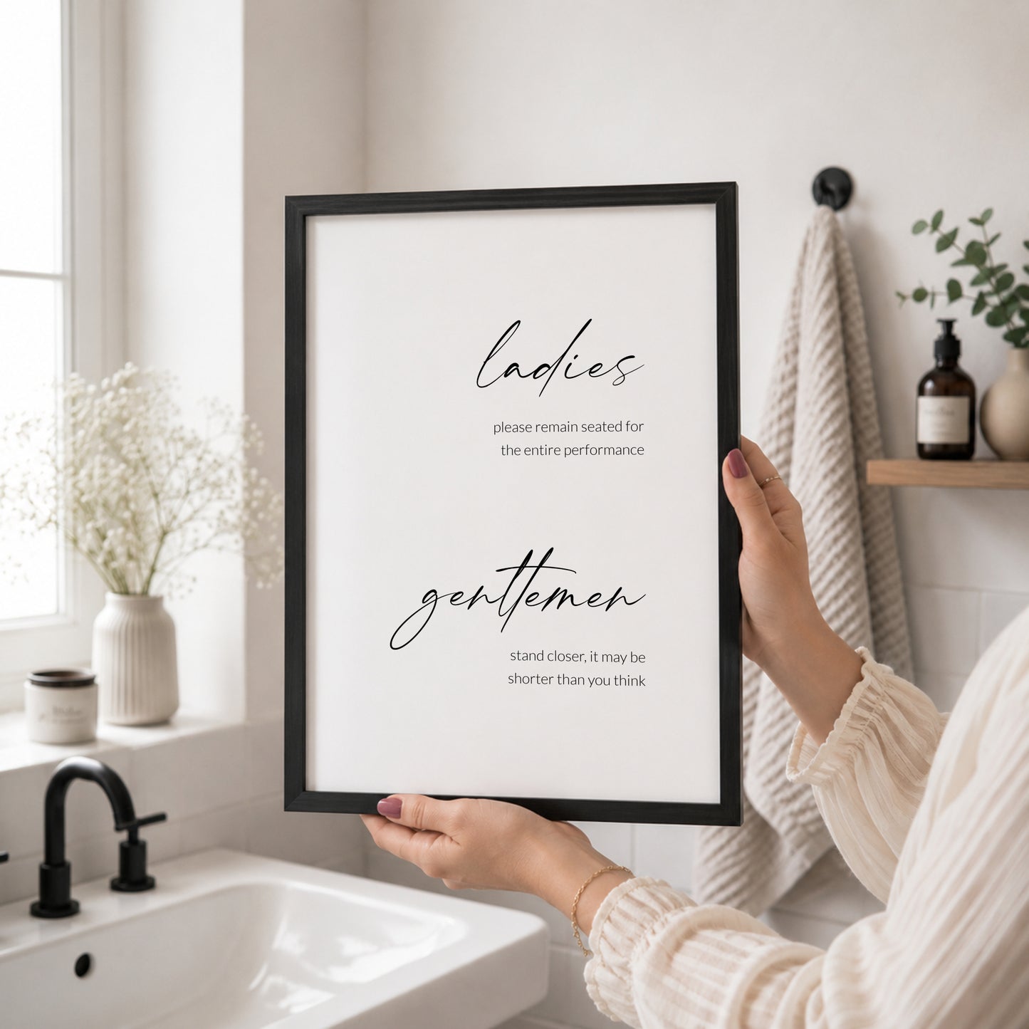 Minimalist funny bathroom typography print with “ladies” in large black script above smaller right-aligned text reading “please remain seated for the entire performance”, and “gentlemen” in large script above right-aligned text reading “stand closer, it may be shorter than you think”, on a white background.