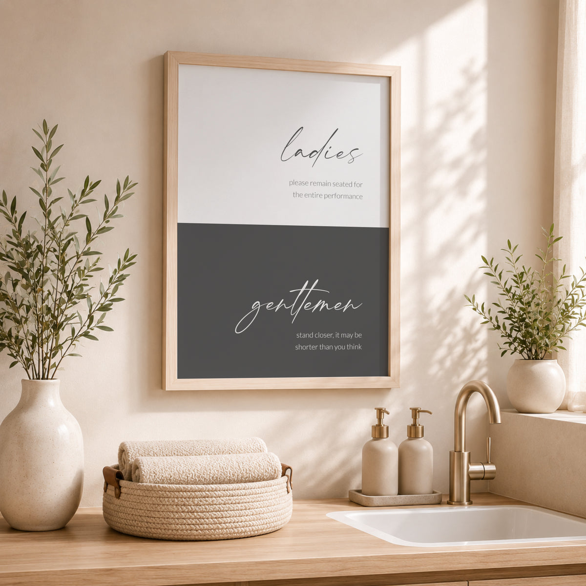 Single portrait typography print for the bathroom. It is colour-blocked in two shades of grey, pale with dark text at the top and dark with pale text at the bottom. The word ladies is positioned prominently in the upper block in a modern script font and gentlemen is in the same style in the lower block. Each then has below it a fun description of appropriate washroom etiquette, shown in a lower case lightweight sans serif font. All text is right-aligned. Styling is elegant and contemporary.