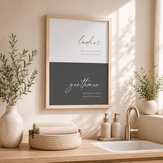 Single portrait typography print for the bathroom. It is colour-blocked in two shades of grey, pale with dark text at the top and dark with pale text at the bottom. The word ladies is positioned prominently in the upper block in a modern script font and gentlemen is in the same style in the lower block. Each then has below it a fun description of appropriate washroom etiquette, shown in a lower case lightweight sans serif font. All text is right-aligned. Styling is elegant and contemporary.