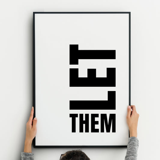 Minimalist black-and-white typography print featuring the phrase ‘LET THEM.’ The word ‘LET’ is displayed vertically in bold, block capital letters, stacked downward, while the word ‘THEM’ appears horizontally beneath in the same bold uppercase font. Clean white background with strong graphic contrast, modern and impactful design.