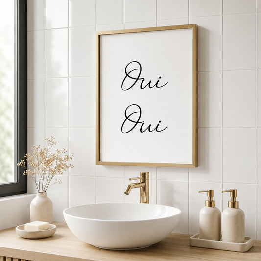 A minimalist black and white wall art print featuring the French words ‘Oui Oui’ displayed across two lines. Text is written in an elegant, flowing script, centred both horizontally and vertically. The typography stands out against a clean white background for a simple, sophisticated look.