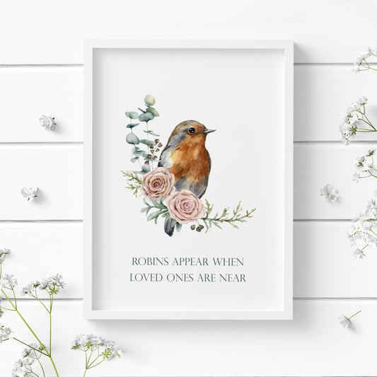 Single portrait print featuring an illustration of a robin perched on foliage and two pink roses. Text below reads: Robins appear when loved ones are near. Text is deep green on a white background and in a formal upper case serif font.
