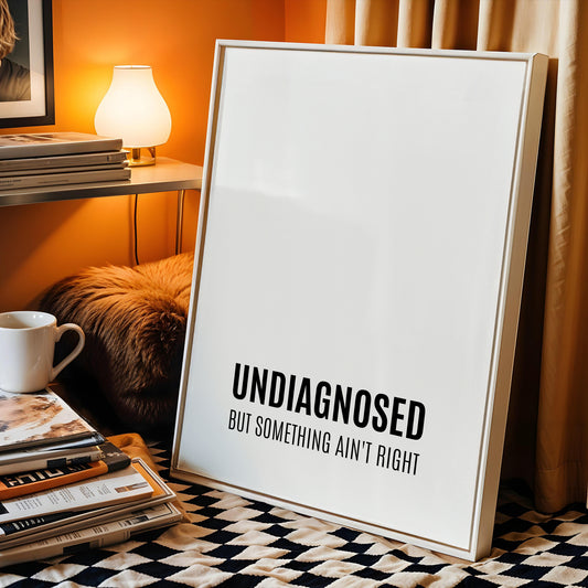 Single portrait typography print featuring the quote "Undiagnosed but something ain't right". The word "undiagnosed" is in bold, with the remaining text positioned below in a smaller font size. All text is in an upper case sans serif font, black on a white background, and aligned to the centre-bottom of the print. Styling is modern and minimalist.