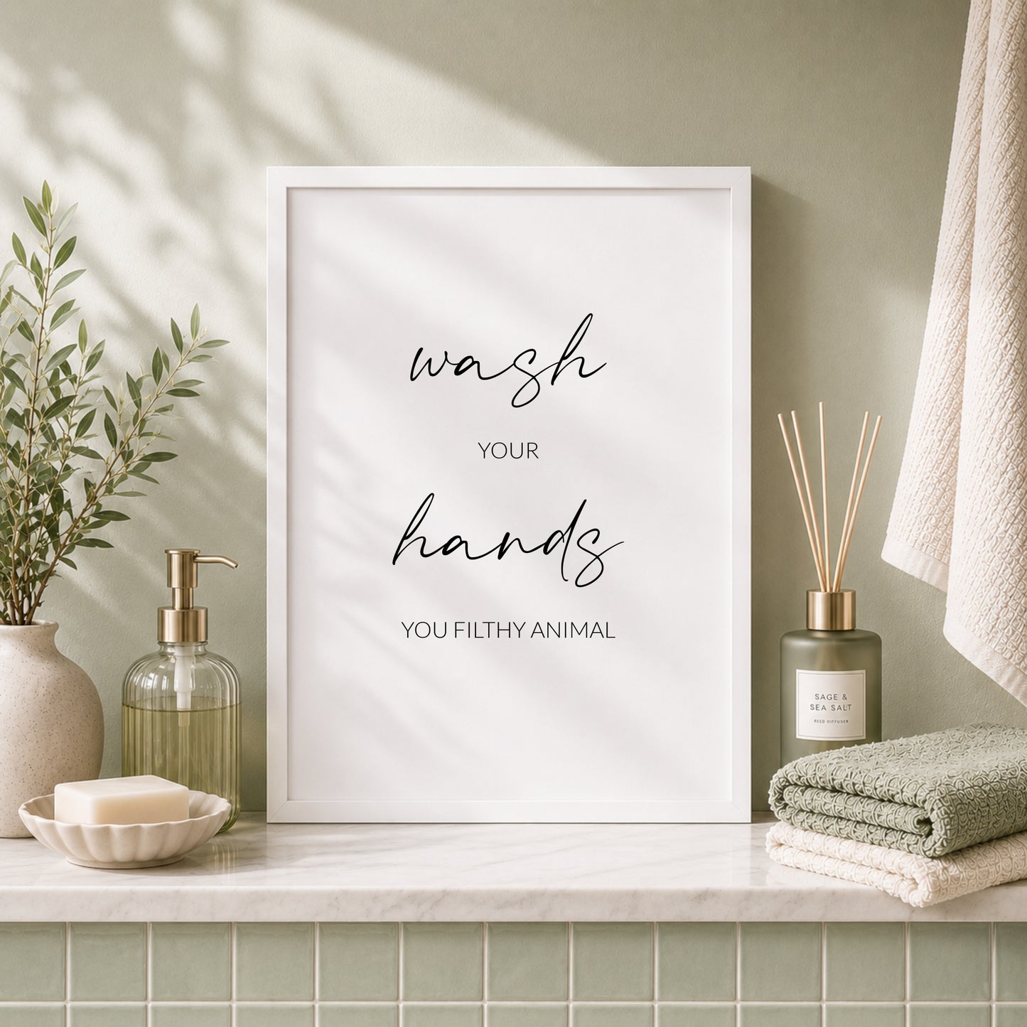 Single portrait typography print shown in a bathroom setting. Text reads: Wash your hands you filthy animal. The words wash and hands are  displayed prominently in an elegant script font.
