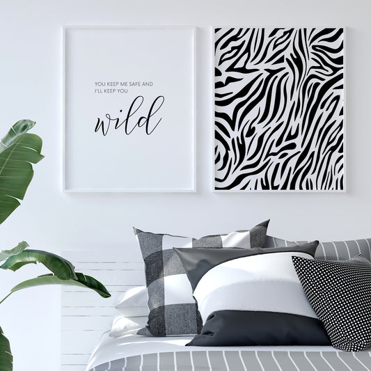 Set of 2 prints. Print 1 features the quote "You keep me safe and I'll keep you wild". The word "wild" is positioned prominently in a striking script font. The remaining text is in a small upper case serif font. Text is black on a white background. Print 2 features a black and white animal print pattern.