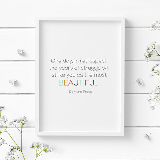 Single portrait typography print. Text reads: One day, in retrospect, the years of struggle will strike you as the most beautiful.  This is followed by an attribution to Sigmund Freud. The word beautiful is highlighted in multicolour.