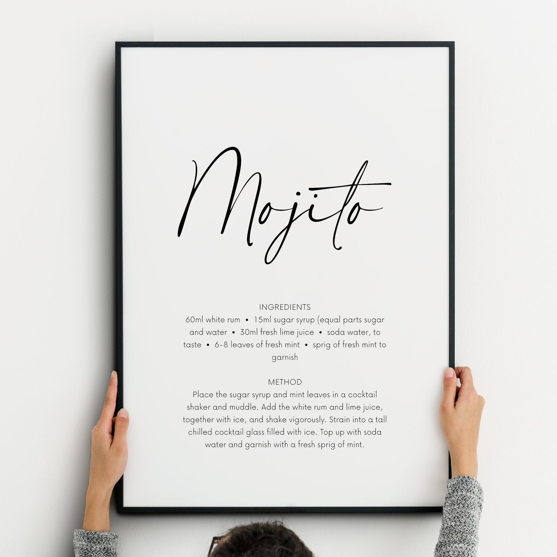Single portrait print featuring the recipe and instructions for a mojito cocktail. The name of the cocktail is positioned prominently in a script font, with the remaining text shown in a crisp sans serif font below. Text is black on a white background.